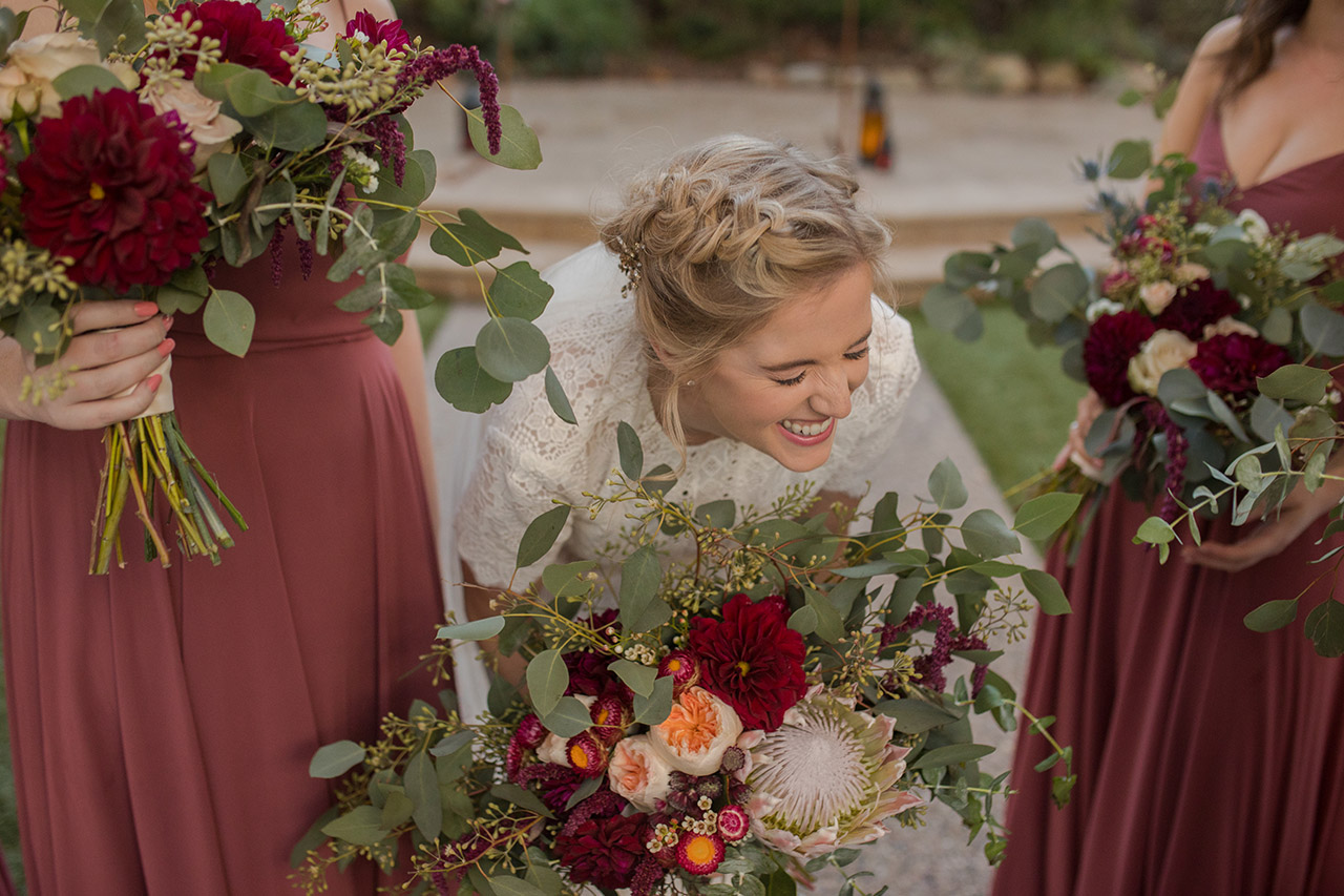 A bride smiling above flowers