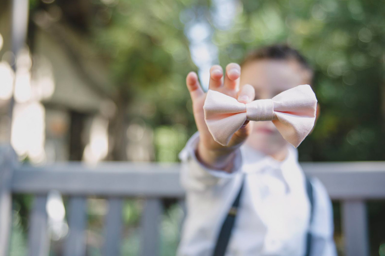 A child holds a bow tie