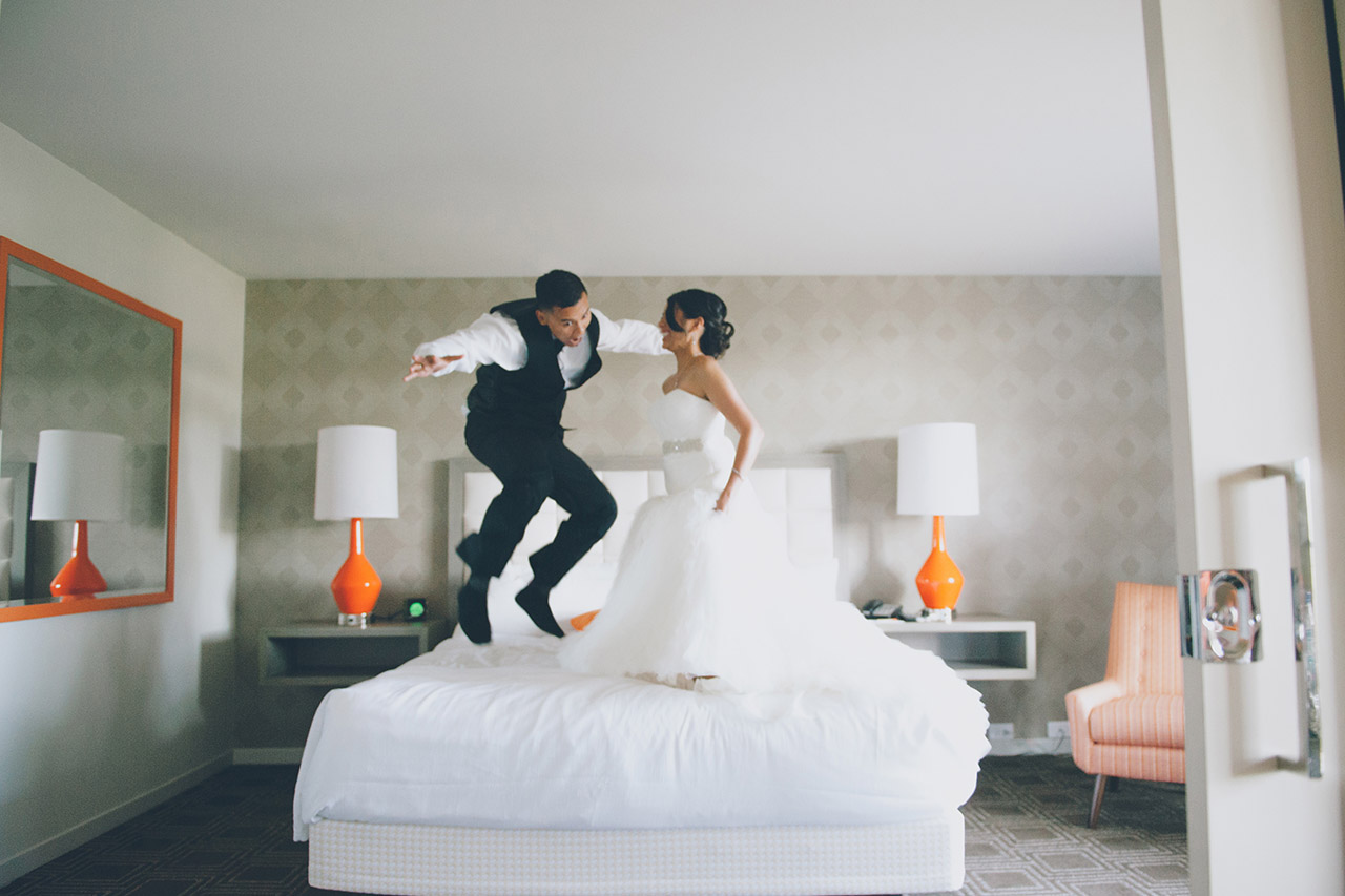 Bride and groom jumping on the bed