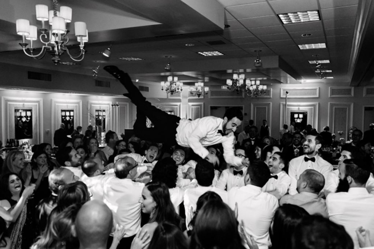 A groom crowd surfing during a reception
