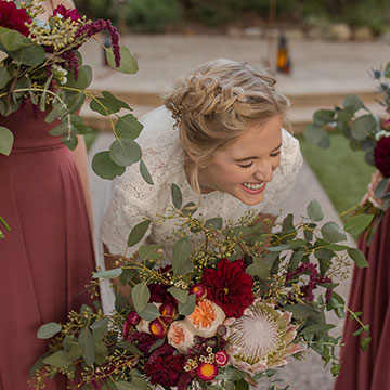 A bride smiling above flowers