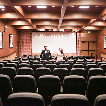 A bridal couple standing in a theatre