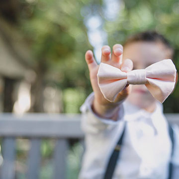 A child holds a bow tie