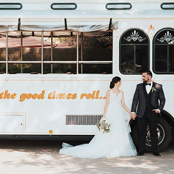 A bridal couple posing in front of the trolley