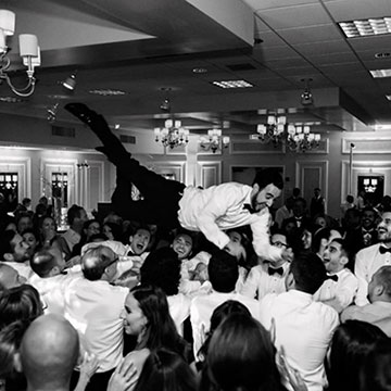 A groom crowd surfing during a reception